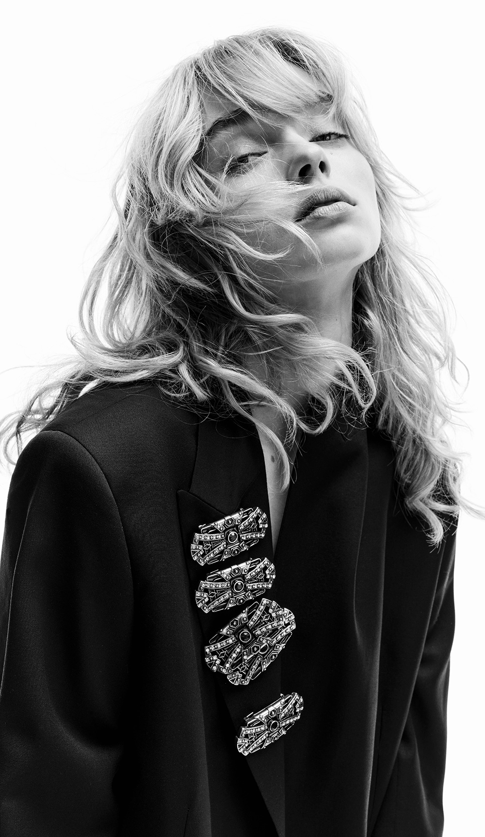 A model wearing black blazer and jewelry