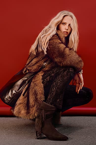 Abby Champion wearing a fur coat & a Youyou bag